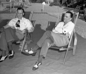 J. Edgar Hoover and his assistant Clyde Tolson sitting in beach lounge chairs, circa 1939. 
